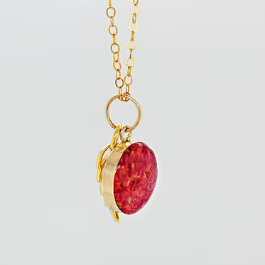 14kt gold-filled cremation pendant with ash and crushed opal inlay. 12 mm pendant. Includes a gold angel wing with opal inlay and ash.