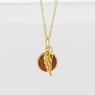14kt gold-filled cremation pendant with ash and crushed opal inlay. 12 mm pendant. Includes a gold angel wing with opal inlay and ash.