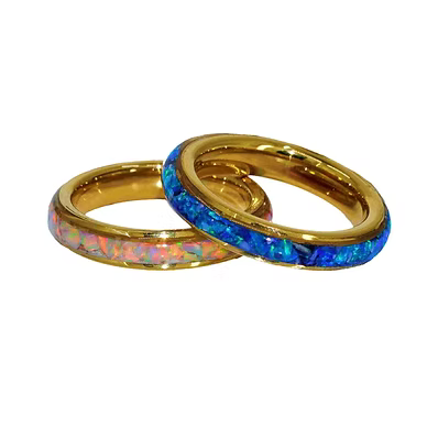 Two gold rings with inlaid opal, one showing a blue and orange pattern and the other a pink and white pattern, on a white background.