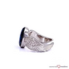 A silver-toned wing ring with a dark blue oval gemstone, shown on a clean white background with a subtle reflection.