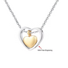 A silver and gold heart pendant necklace on a white background, featuring a silver open heart with a gold heart inside and a small red arrow pointing to the side with the text 'With Free Engraving'.