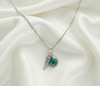 Cremation Initial Charm Angel Wing Pendant in .960 Silver.  Each piece features an opal accent and a delicate angel wing, symbolizing peace and protection. 
