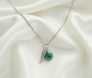 Cremation Initial Charm Angel Wing Pendant in .960 Silver.  Each piece features an opal accent and a delicate angel wing, symbolizing peace and protection. 
