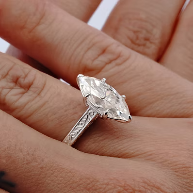 solid .960 silver with intricate engraved detailing throughout, it features a stunning 3.5 carat marquise-cut moissanite diamond as the centerpiece