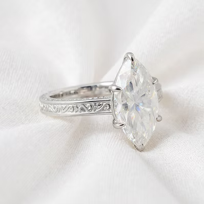 solid .960 silver with intricate engraved detailing throughout, it features a stunning 3.5 carat marquise-cut moissanite diamond as the centerpiece