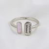 A silver open ring with two rectangular ends, one featuring a small iridescent opal-like inlay and the other engraved with 'Forever Missed' and a small '925' mark inside, shown on a white background.