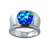 A silver-toned ring featuring a round cabochon opal gemstone with vibrant blue and green play-of-color, set against a plain white background.