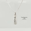 A silver vertical rectangular pendant necklace engraved with the name 'Name' in black lettering, suspended from a delicate silver chain against a light gray background. To the right, black text reads 'Free Engraving 1 Side.