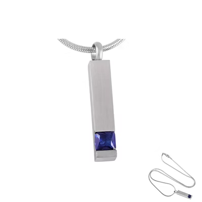 A silver-toned rectangular pendant necklace with a faceted blue gemstone at the bottom, shown on a white background with a smaller inset view of the necklace chain and pendant clasp.