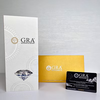  GIA (Graded & Certified International) diamond report packaging set, featuring a white textured report card, a gold certificate envelope, and a black diamond certification card on a light gray background.